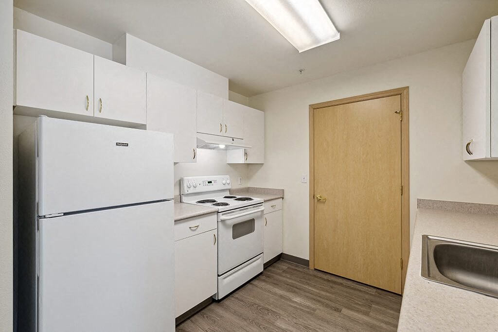 Kitchen with white appliances at Ballinger Court Senior Apartments in Edmonds WA